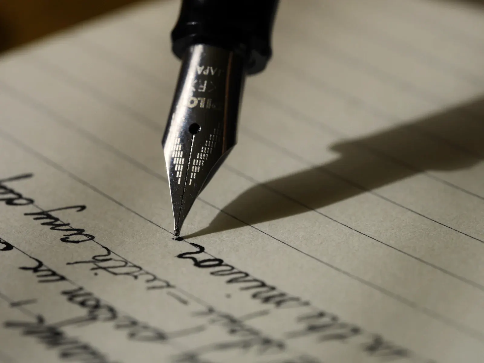 A fountain pen resting on a handwritten page.